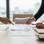 Mãos em mesa de reunião com documentos e gráficos sobre Lei do Bem e PD&I para grandes empresas